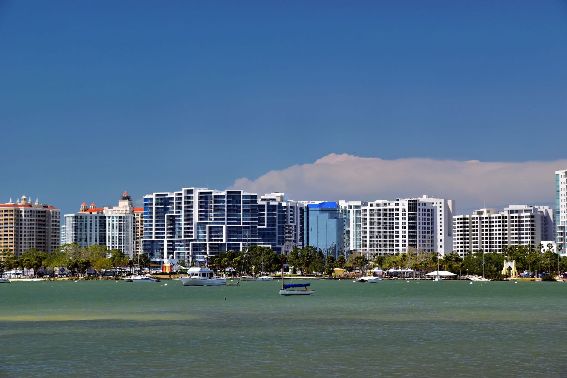 Panoramic view of Sarasota, Florida skyline against a blue sky, featuring modern architecture and waterfront.